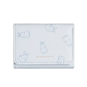 Dettaglio del portafoglio trifold azzurro con stampe di coniglio e logo dorato