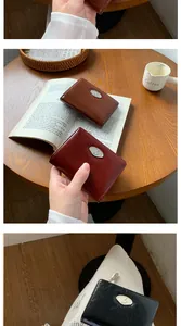 Detail of vintage pleated leather envelope wallets in brown, burgundy, and black colors