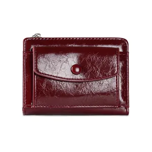 Detail view of wine red oil wax leather wallet with smooth zipper and button pocket