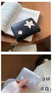 Close-up of small zipper wallet with star cut-out design in black and silver metallic