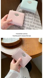 Detail of compact envelope wallets showing pebbled leather texture and metal oval buckle