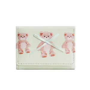 Dettaglio del portafoglio verde chiaro con orsetti rosa stampati e fiocco elegante