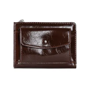 Detail of dark brown faux leather wallet featuring a snap button pocket and top zipper