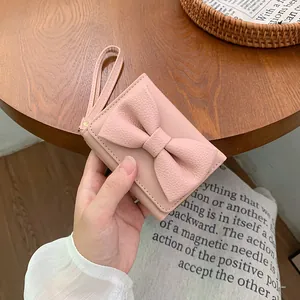 Mini portafoglio rosa da donna con fiocco decorativo e cinturino da polso chic