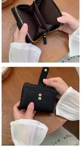 Detail of black pebbled leather wallet showing accordion compartments and gold zipper