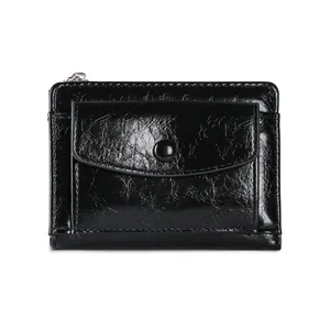 Detail of black glossy crackle leather wallet with snap button pocket and zipper closure