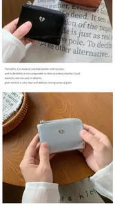 Détail de portefeuilles en cuir craquelé noir et argent avec fermoir cœur métallique