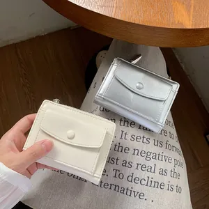 Short minimalist faux leather wallets in cream and silver with snap pocket and zip closure