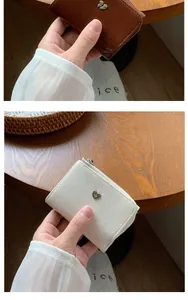 Détails de portefeuilles compacts à trois volets avec boucle en cœur et texture en cuir plissé