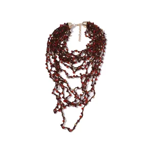 Macro detail of multi-layer handmade bohemian beaded necklace with red and gold beads