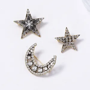 Detailed view of three-piece celestial brooch set with pavé crystals on gold-tone metal