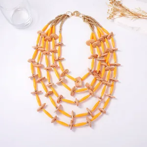 Detail van vijf-laagse Boheemse ketting met gele buisvormige kralen en marmeren stenen