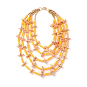 Detail van een vijflaagse kralenketting met gele buisjes en perzikkleurige schijfkralen