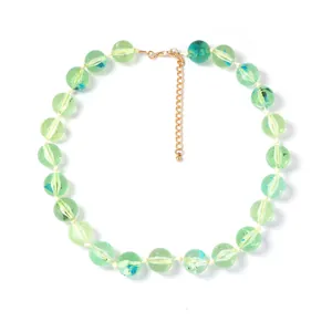 Détail d'un collier de perles fait main vert clair avec un fermoir mousqueton doré