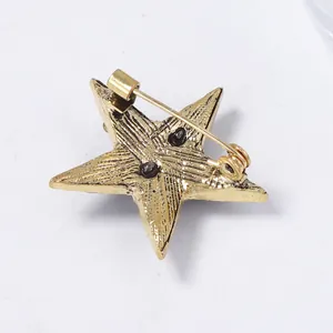 Detailed back view of a star brooch showing the secure pin fastener and metal texture