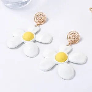 Elegante weiße Emaille-Blumenohrringe mit goldenen Steckern auf minimalistischem Grund