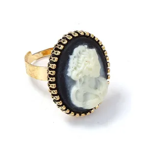 Bague camée vintage dorée avec silhouette féminine blanche sur fond ovale noir