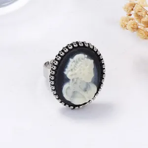 Gros plan d'une bague camée vintage avec profil de femme sur fond noir élégant
