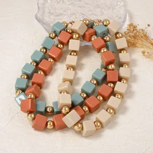 Vue détaillée du collier géométrique multicouche avec perles mates rouge brique et vert