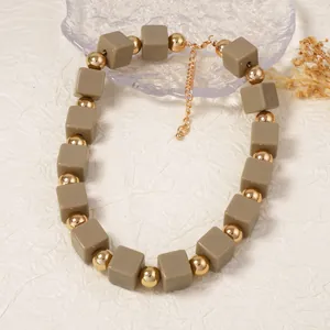 Détail d'un collier bohème multicouche avec perles cubes vert olive et fermoir doré