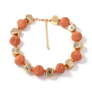 Moderne hars kralenketting met terracotta kiezels en gouden geometrische blokjes