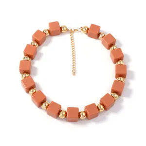 Détail du collier bohème avec perles carrées orange et fermoir mousqueton doré brillant