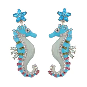 Detailed close-up of seahorse earrings with colorful crystals and blue starfish stud