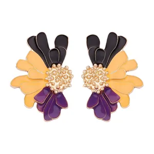 Détail de boucles d'oreilles fleurs en émail avec pétales noirs, orange et violets