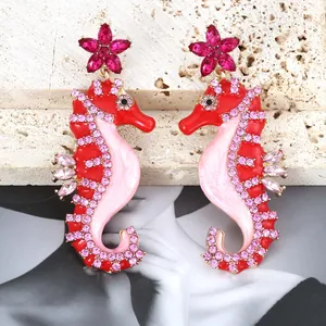 Detail of seahorse earrings with red pink enamel and sparkling rhinestones