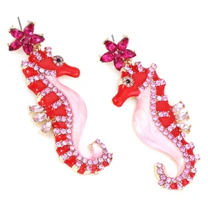Detailed view of seahorse earrings with red and pink enamel and sparkling rhinestones