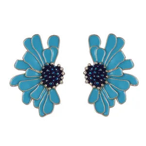 Détail de boucles d'oreilles fleurs en émail bleu clair avec centres bleus à points dorés