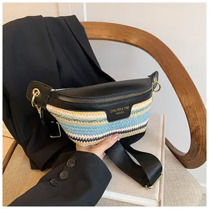 Detail of woven crossbody bag with color-block stripes and gold metallic logo branding