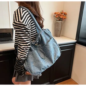 Detail der blauen Denim-Tasche mit Kordelzugstruktur und praktischer Seitentasche