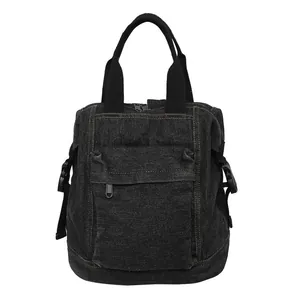 Detailed macro view of black denim fabric texture and reinforced handle on the backpack