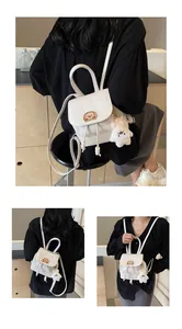 Dettaglio mini zaino bianco con toppa a cartone e portachiavi a forma di animale