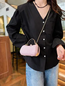 Pink glitter evening bag with gold chain strap shown as a crossbody on a model