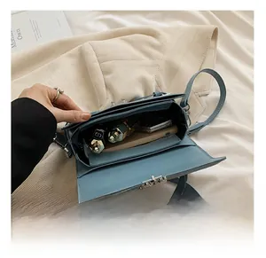 Detail view of the spacious blue leather crossbody bag interior with silver metal lock