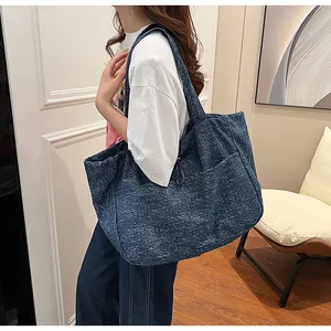 Detail der dunkelblauen Denim-Tragetasche mit Außentasche und robusten Schultergurten