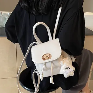 Mini zaino bianco in pelle PU con ricamo a fumetti indossato da modella casual