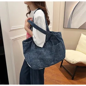 Detail einer großen Tragetasche aus strukturiertem Stoff mit Seitenfach in Denim-Blau
