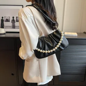 Elegant black pleated cloud bag featuring large pearl chain and wide leather strap