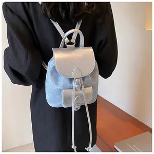 Mini backpack in blue denim and silver leather shown being worn by a fashion model