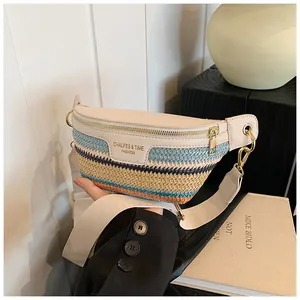 Close-up of woven color-block detail and metallic logo on casual leather crossbody bag
