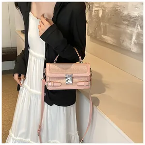 Pink woven mini square bag with silver metal lock and adjustable shoulder strap detail