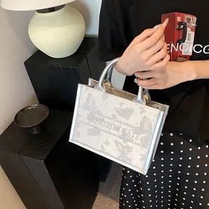 Silver metallic tote bag with butterfly print and decorative text strap for women