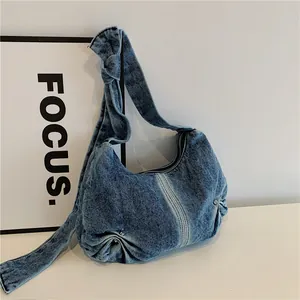 Relaxed blue washed denim hobo bag with knotted strap and trendy pleated design
