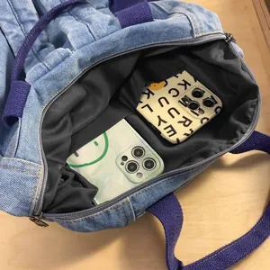 Internal view of denim tote bag showing lining, inner pocket, and phone storage capacity