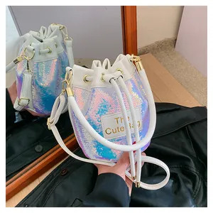 Détail du sac seau à paillettes blanches avec effet laser et étiquette The Cute Bag