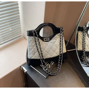 Détail du sac seau en denim bleu clair avec matelassage et bandoulière chaîne argent