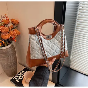 Détails du sac à bandoulière en denim matelassé avec cuir marron et chaîne dorée
